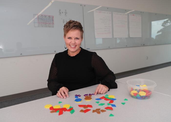 Teacher at desk with tile shapes